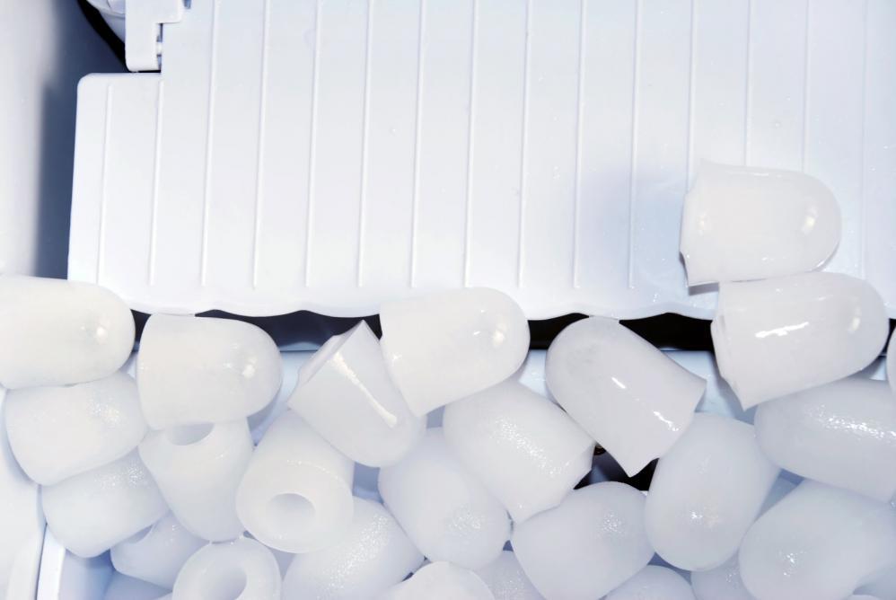 Pieces of ice over white plastic in an ice maker